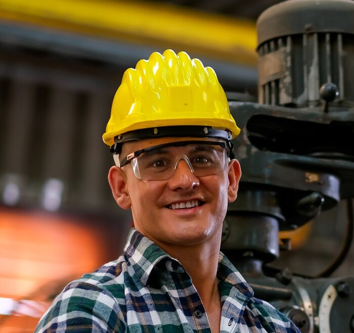 Front view of smart technician or engineer worker with protective helmet stand with confident